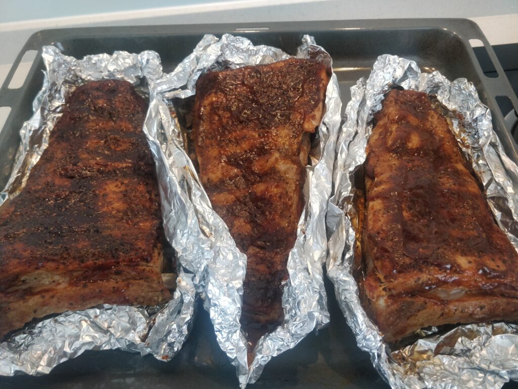 The slow-cooked BBQ pork ribs after coming out of the oven for the final time. The meat will be soft, plenty of flavor but not sloppy.